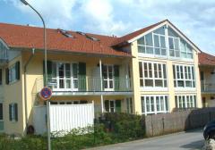 Mehrfamilienhaus in Bad Tölz: Holzfenster mit weißer Oberfläche, grüne Holzfensterläden