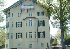 Rathaus in Bad Heilbrunn: Holzfenster mit weißer Oberfläche und Fensterläden